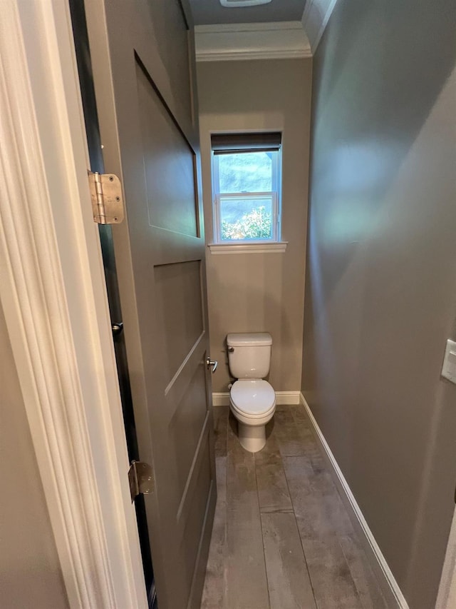 bathroom with toilet, baseboards, and ornamental molding