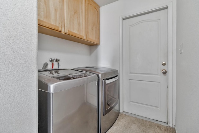 clothes washing area with cabinet space and washing machine and dryer