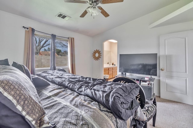 carpeted bedroom featuring ensuite bath, a ceiling fan, visible vents, and arched walkways