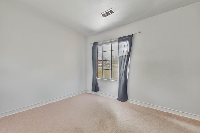 unfurnished room with visible vents, speckled floor, and baseboards