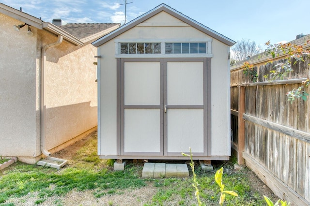 view of shed featuring fence