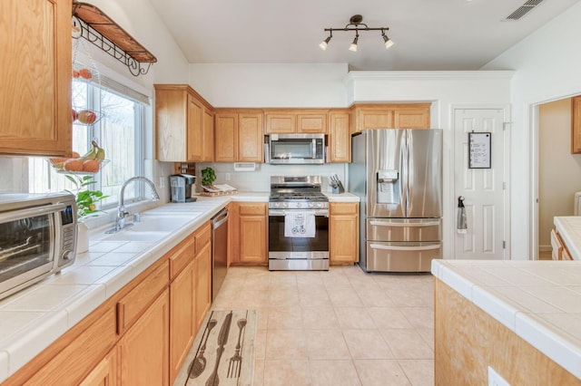 kitchen featuring visible vents, tile countertops, light tile patterned floors, appliances with stainless steel finishes, and a sink