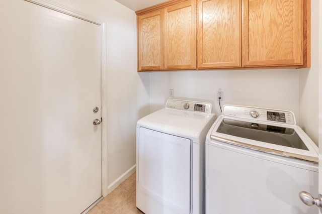 laundry room featuring cabinet space, light tile patterned floors, independent washer and dryer, and baseboards