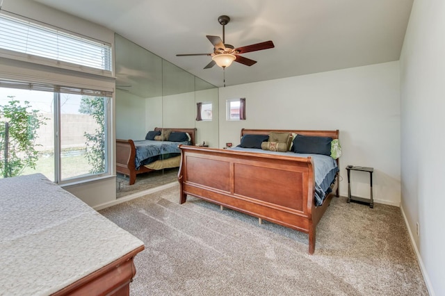 bedroom featuring light colored carpet, ceiling fan, baseboards, and vaulted ceiling