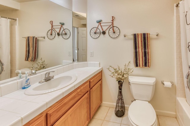 bathroom featuring tile patterned flooring, toilet, vanity, and baseboards