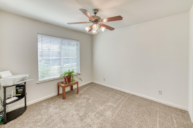 carpeted spare room with baseboards and a ceiling fan