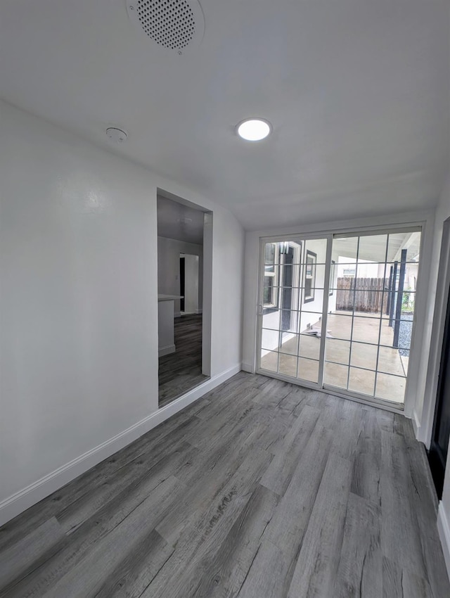 unfurnished room featuring baseboards and wood finished floors