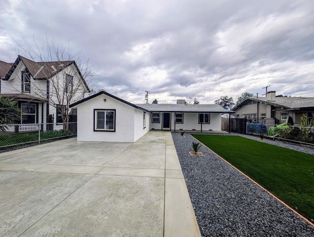 ranch-style house with stucco siding, a front yard, and fence