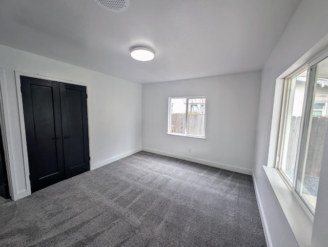 carpeted empty room featuring visible vents and baseboards