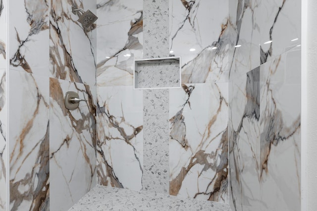 interior details featuring a marble finish shower