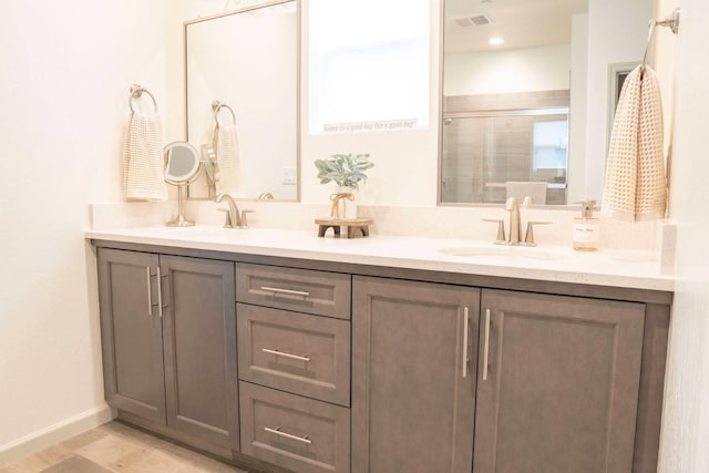 full bath featuring double vanity, visible vents, a shower stall, and a sink