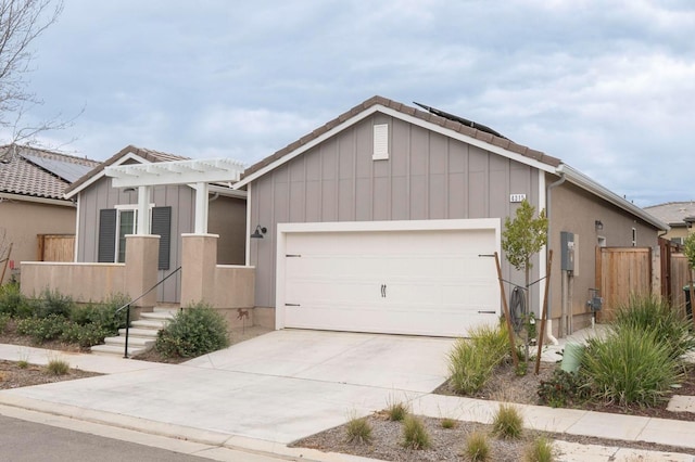 view of front facade featuring a garage, board and batten siding, driveway, and fence