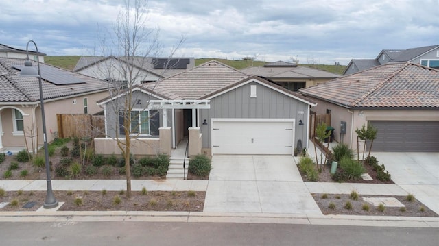 view of front of home featuring a garage, fence, driveway, and a tiled roof