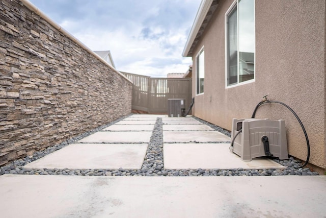 view of patio / terrace with fence, central AC, and ac unit