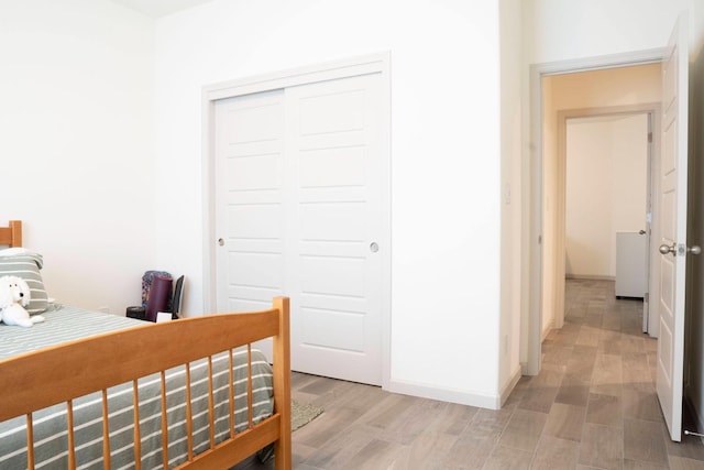 bedroom featuring a closet, baseboards, and light wood-style floors