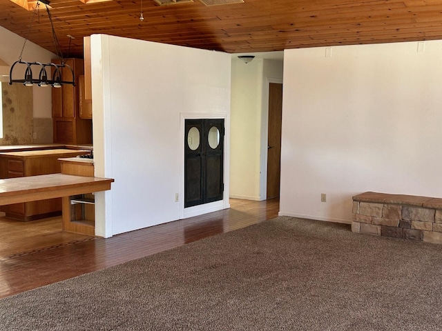 unfurnished living room featuring wooden ceiling, carpet, and visible vents