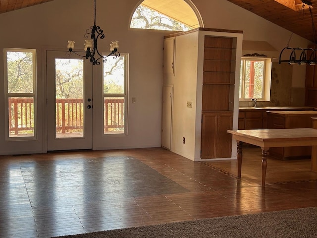 unfurnished dining area with lofted ceiling, a chandelier, and a sink