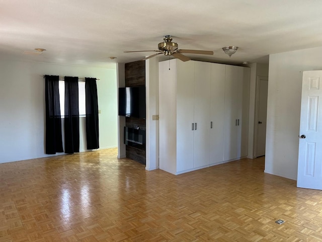 unfurnished living room with a ceiling fan and a fireplace