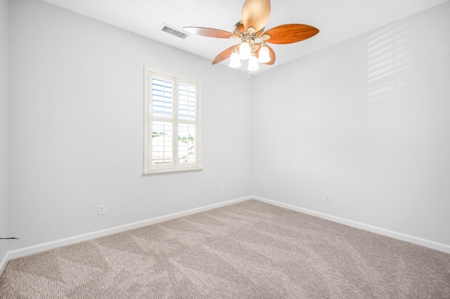 carpeted empty room featuring visible vents, baseboards, and ceiling fan