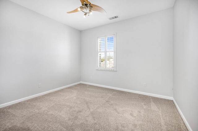 carpeted spare room featuring a ceiling fan, baseboards, and visible vents