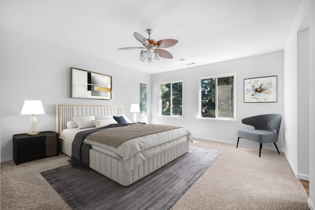 bedroom featuring visible vents, baseboards, carpet, and a ceiling fan