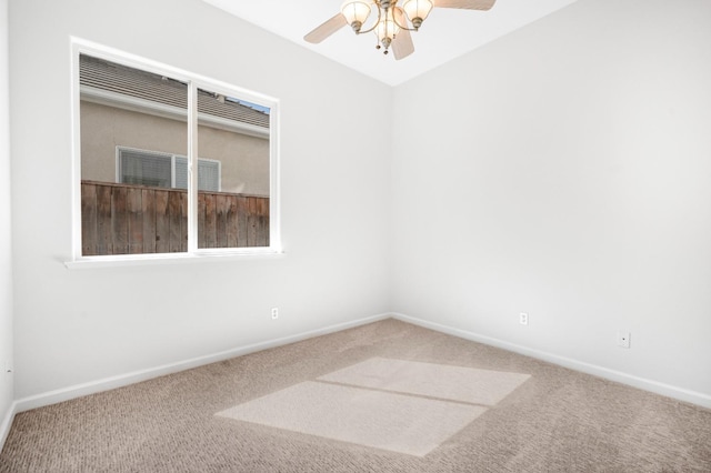 carpeted empty room featuring a ceiling fan and baseboards