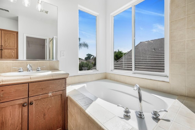 full bathroom featuring vanity, a garden tub, and visible vents