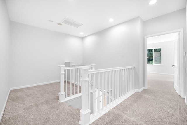 hallway with recessed lighting, an upstairs landing, baseboards, and carpet floors