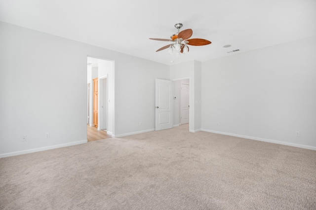 spare room with visible vents, light carpet, and baseboards