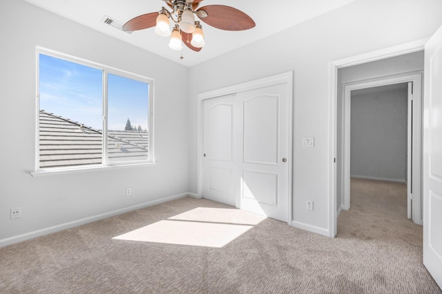 unfurnished bedroom with a closet, baseboards, carpet, and a ceiling fan