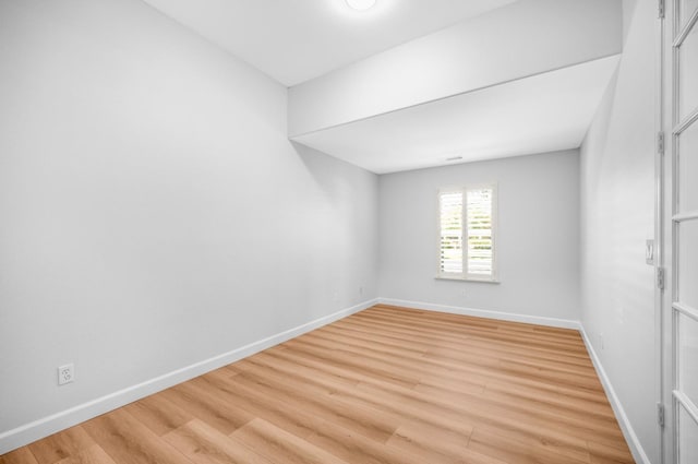 spare room with light wood finished floors and baseboards