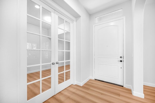 entryway with french doors, light wood-type flooring, and baseboards