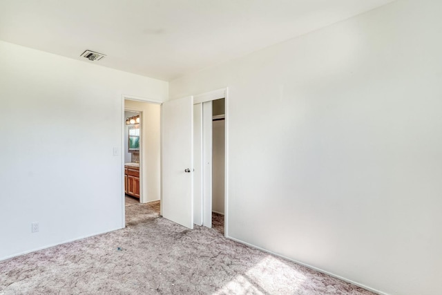 unfurnished bedroom with a closet, visible vents, and carpet floors