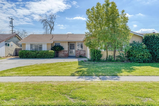 single story home featuring brick siding, a front yard, and fence