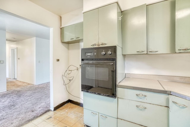 kitchen with oven, light carpet, and light countertops