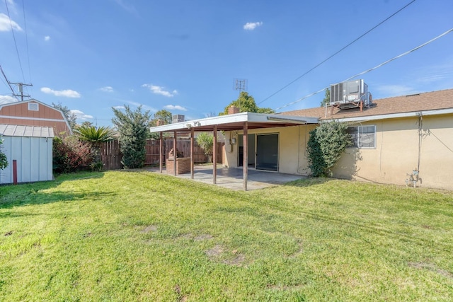 view of yard with fence, cooling unit, an outdoor structure, a storage unit, and a patio