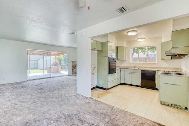 kitchen featuring visible vents, light colored carpet, black appliances, and green cabinets