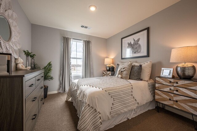 bedroom featuring visible vents, dark carpet, and baseboards