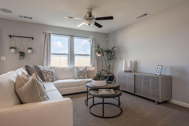 living room with visible vents, carpet floors, baseboards, and a ceiling fan