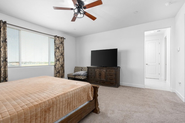 carpeted bedroom featuring baseboards and ceiling fan