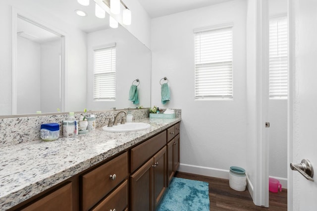 bathroom featuring baseboards, wood finished floors, and vanity