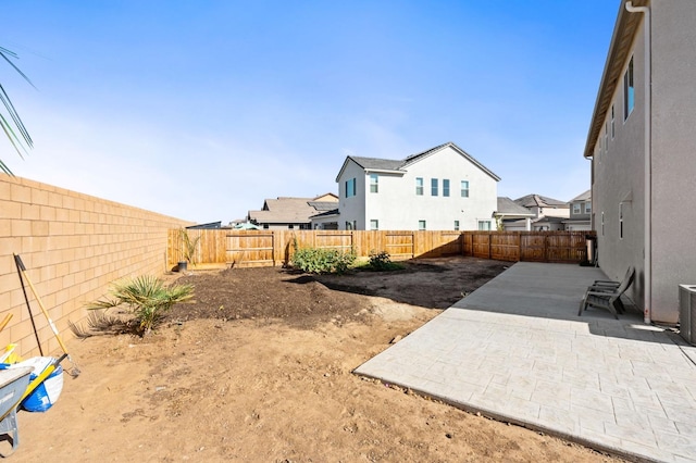 view of yard with a residential view, a patio, and a fenced backyard