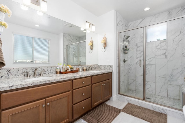 full bathroom with a sink, a marble finish shower, visible vents, and double vanity