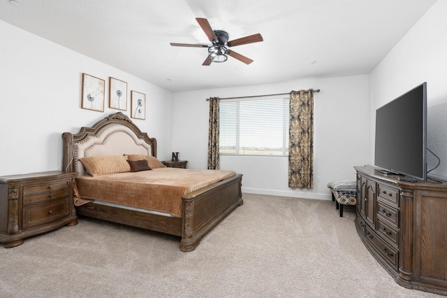 bedroom with a ceiling fan, baseboards, and light carpet