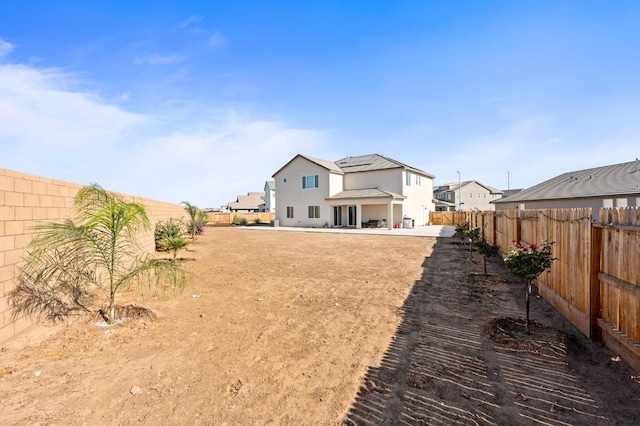 back of property with roof mounted solar panels, a patio, and a fenced backyard