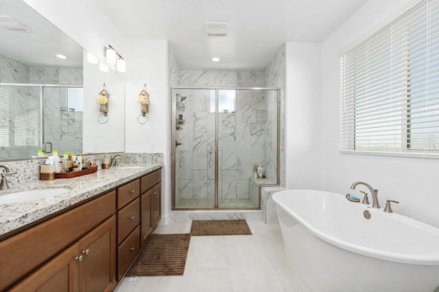 bathroom with a marble finish shower, a soaking tub, double vanity, recessed lighting, and a sink