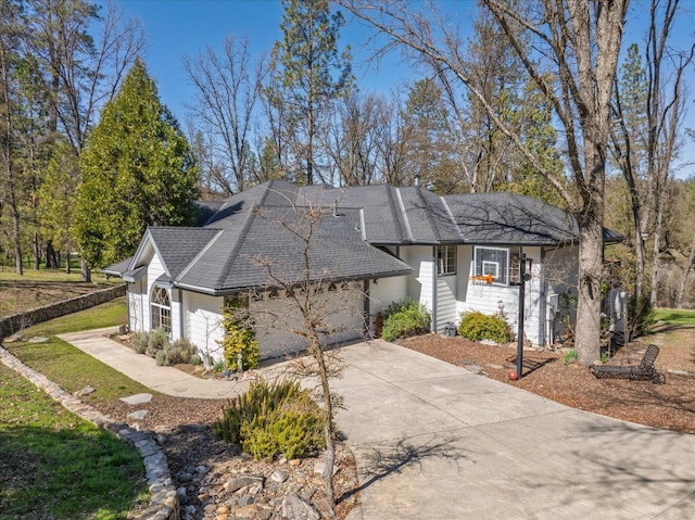 view of front of property with driveway, a front lawn, a garage, and roof with shingles