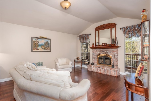 living room with baseboards, lofted ceiling, a brick fireplace, and wood finished floors