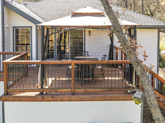 wooden deck featuring a gazebo and outdoor dining area