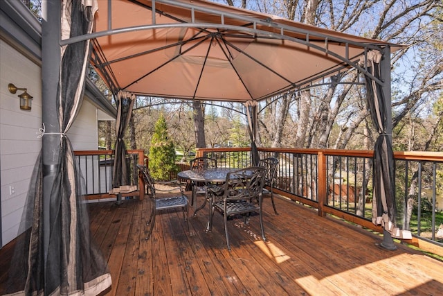 wooden terrace with a gazebo and outdoor dining area